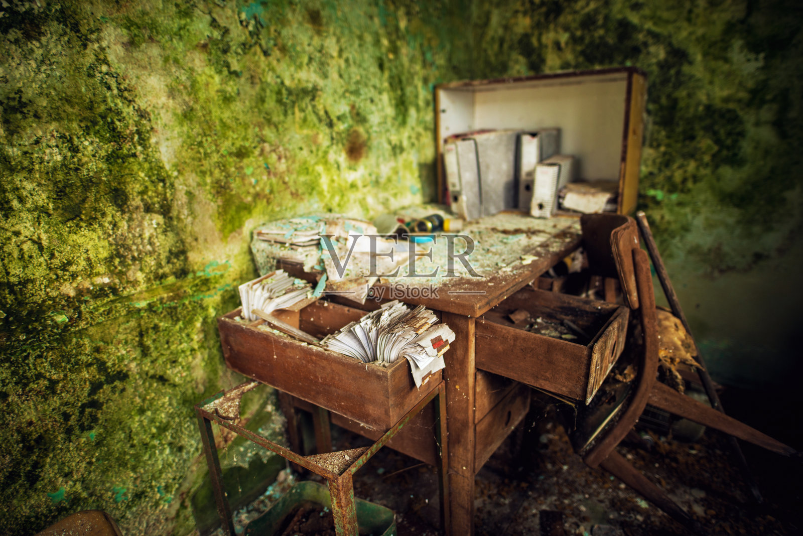 在废弃的废弃的房子里，被遗忘的旧的被损坏的办公桌和打开的抽屉盒子的近距离聚焦视图。照片摄影图片