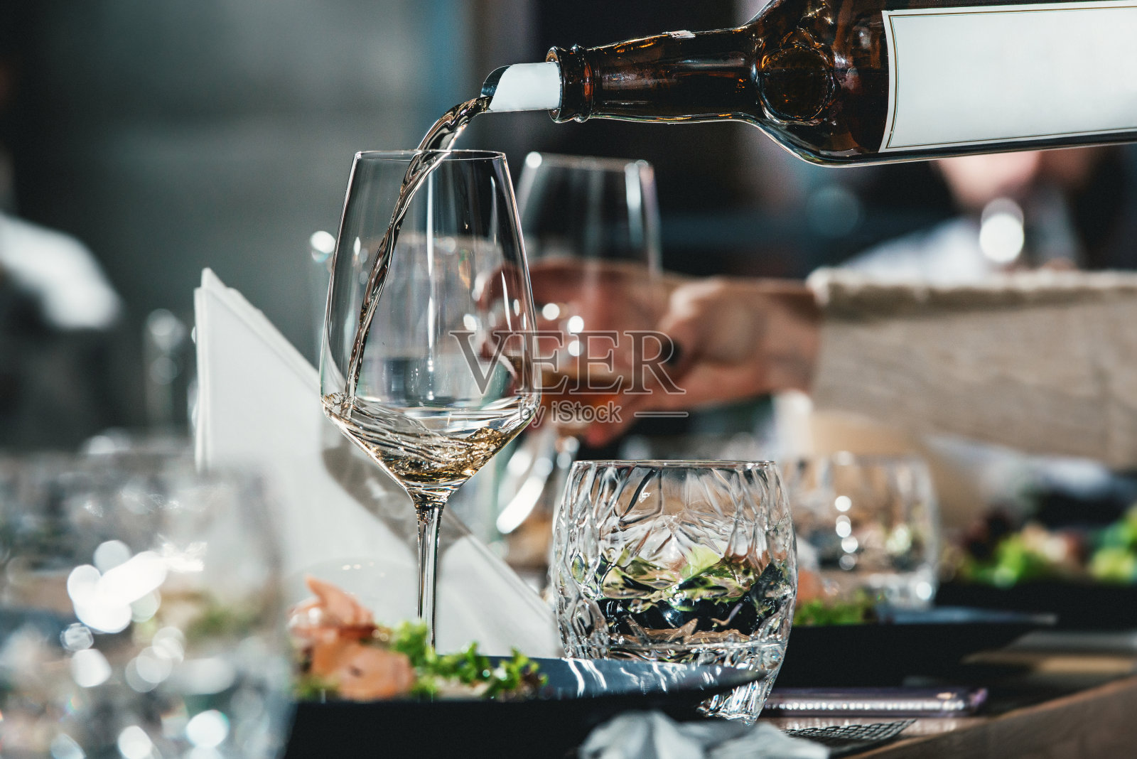 品酒师在品酒时将葡萄酒倒入玻璃杯照片摄影图片