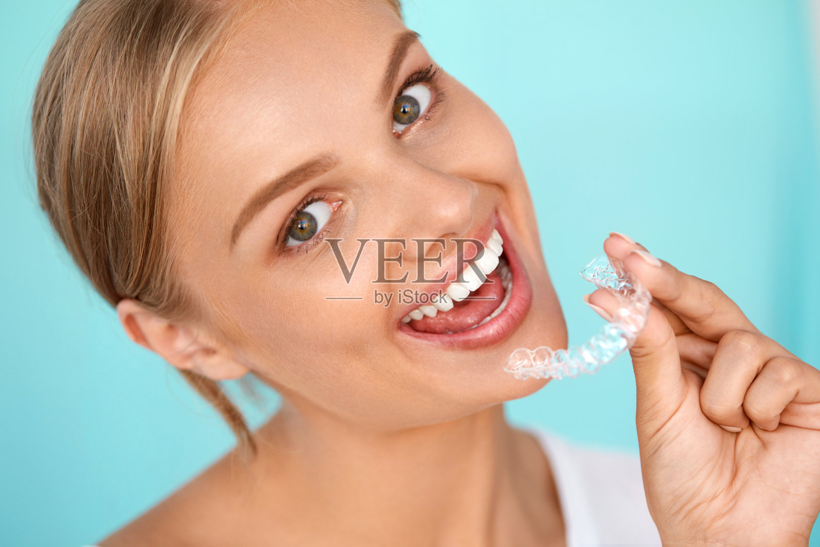 微笑的女人与白牙齿持有牙齿美白托盘照片摄影图片