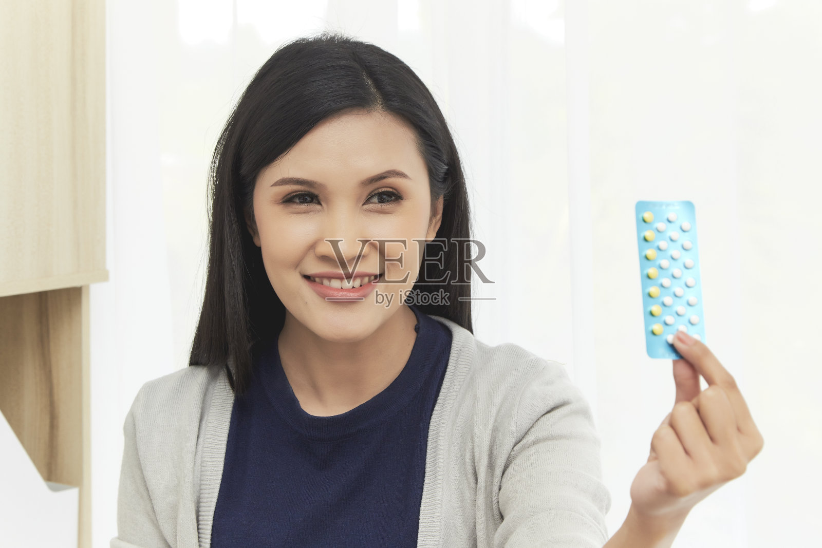 年轻的亚洲女人在家吃药照片摄影图片