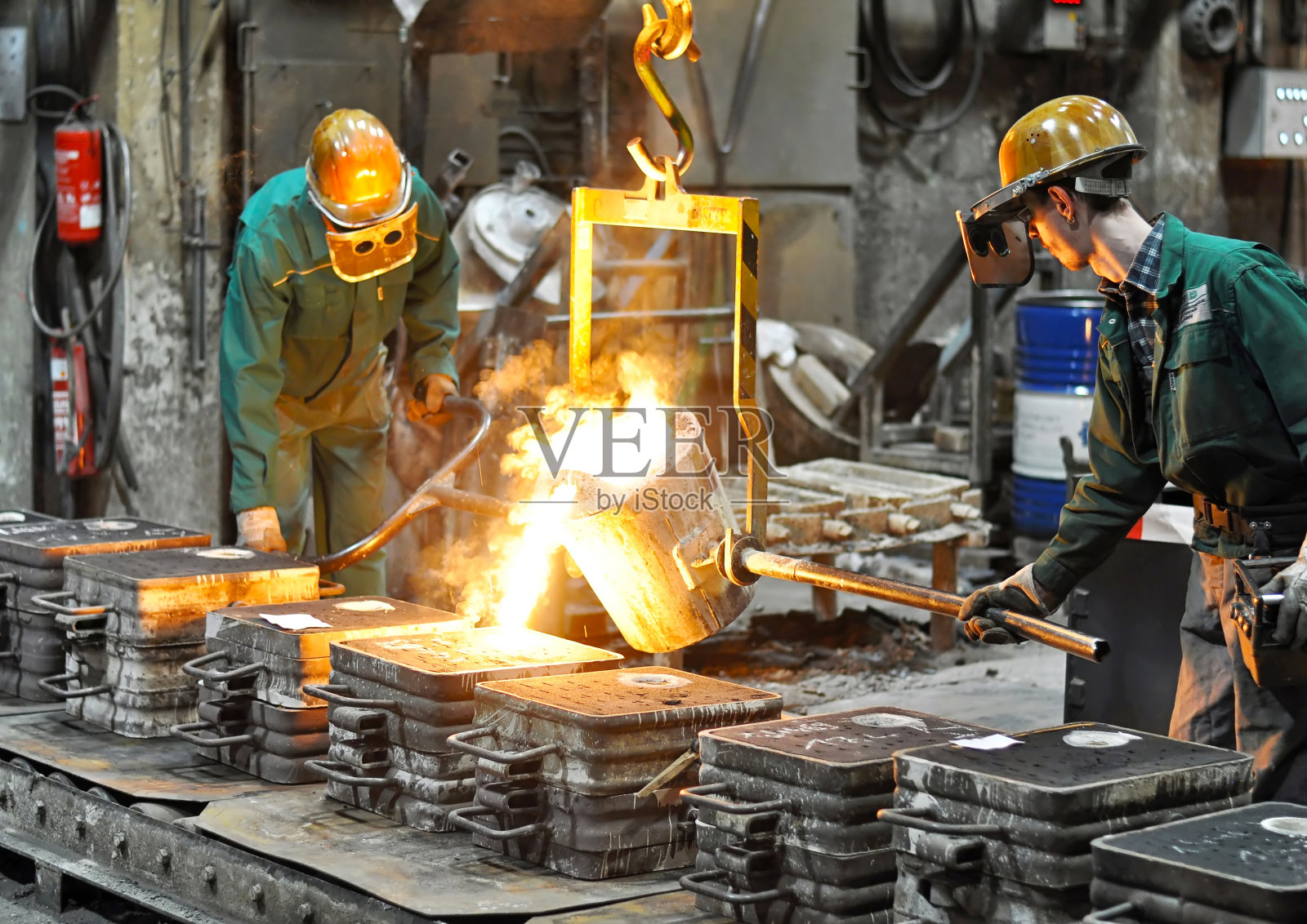 一组工人在铸造厂的熔化炉-生产钢铸件在一个工业公司照片摄影图片