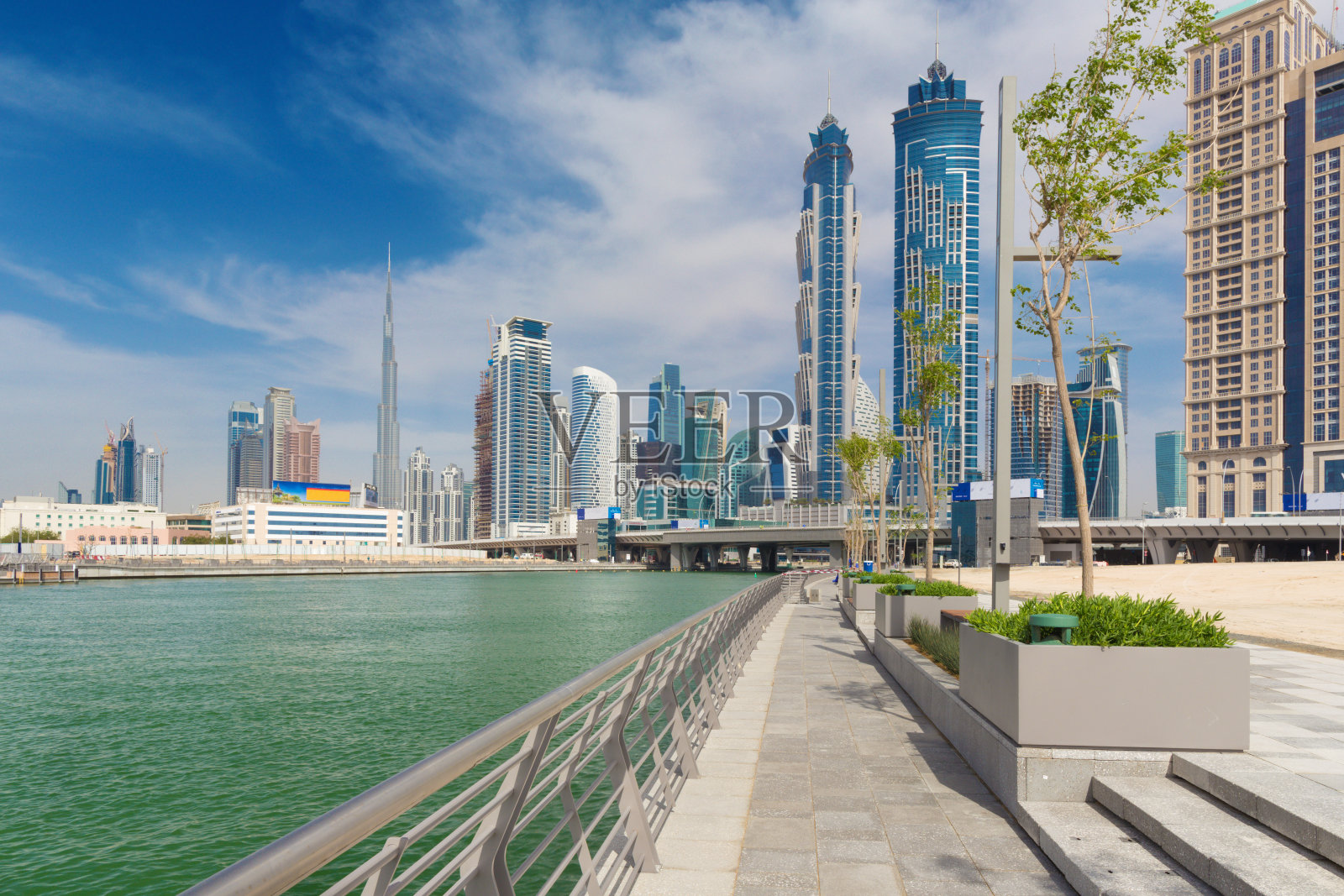 迪拜——摩天大楼高耸而过，背景是新运河大道和哈利法塔。照片摄影图片