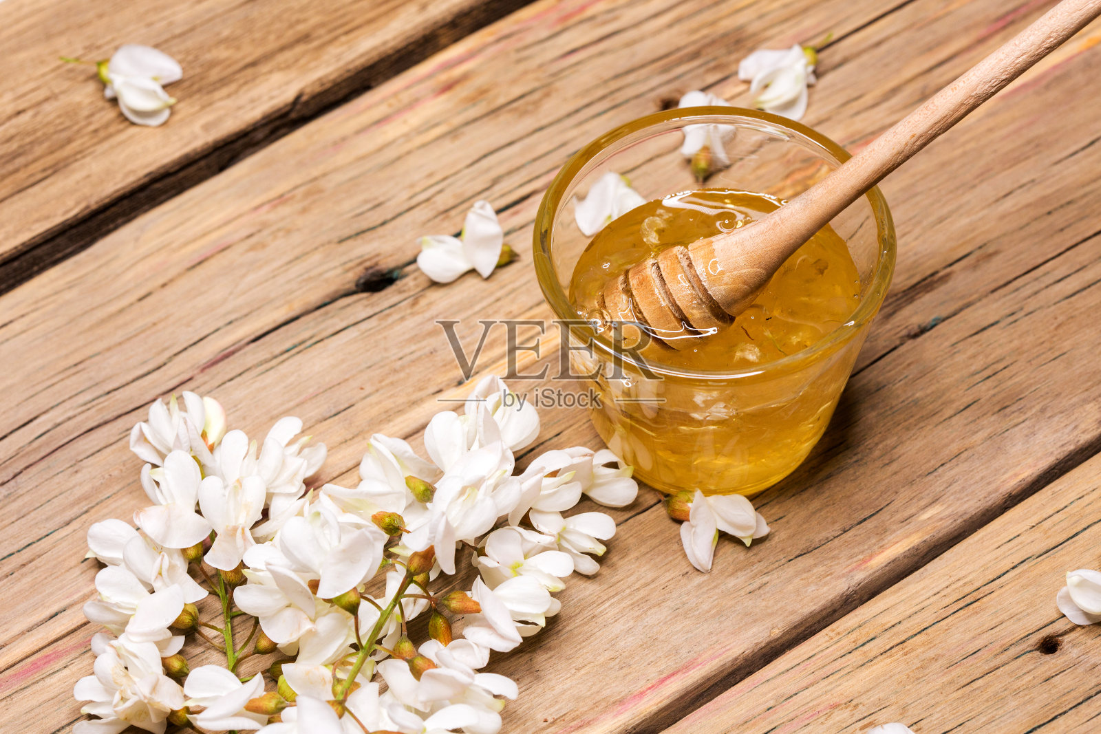 蜂蜜和金合欢花在一个木制的背景照片摄影图片