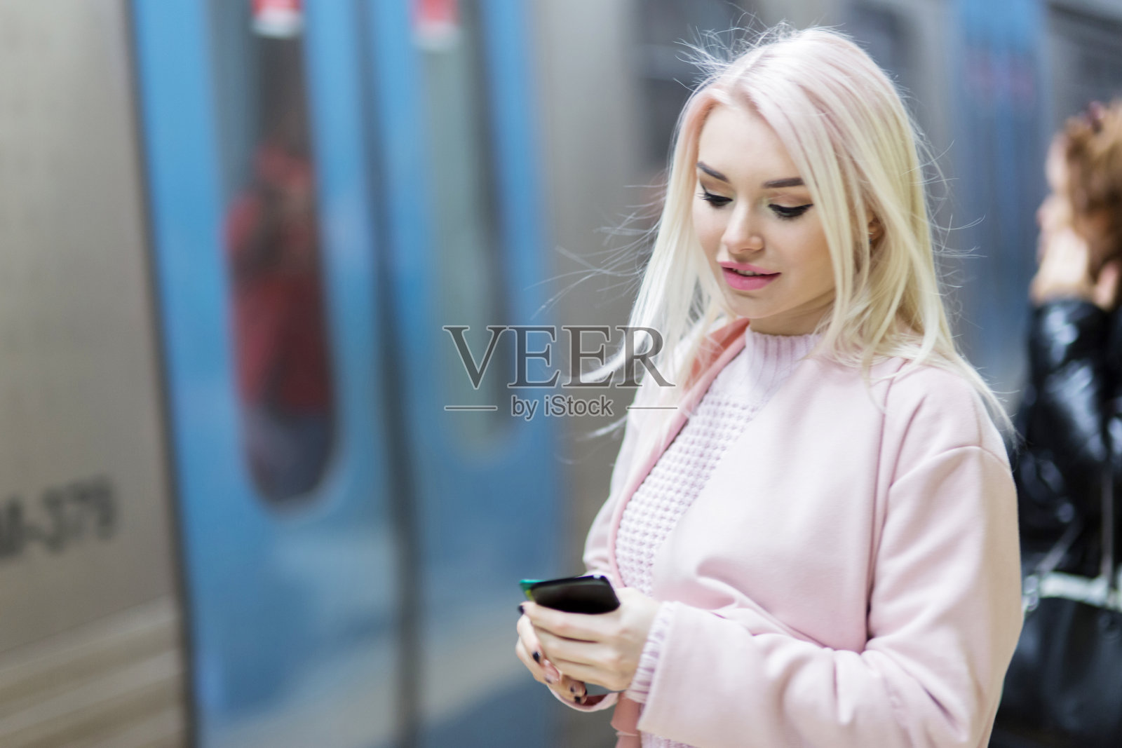 在地铁上使用智能手机的优雅女性照片摄影图片