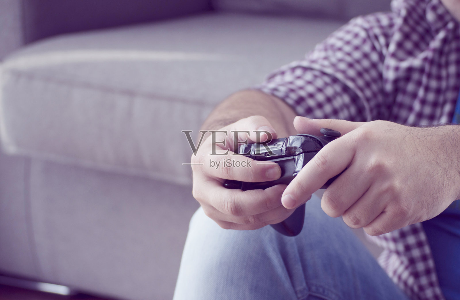一个年轻人在家里用操纵杆玩电子游戏照片摄影图片