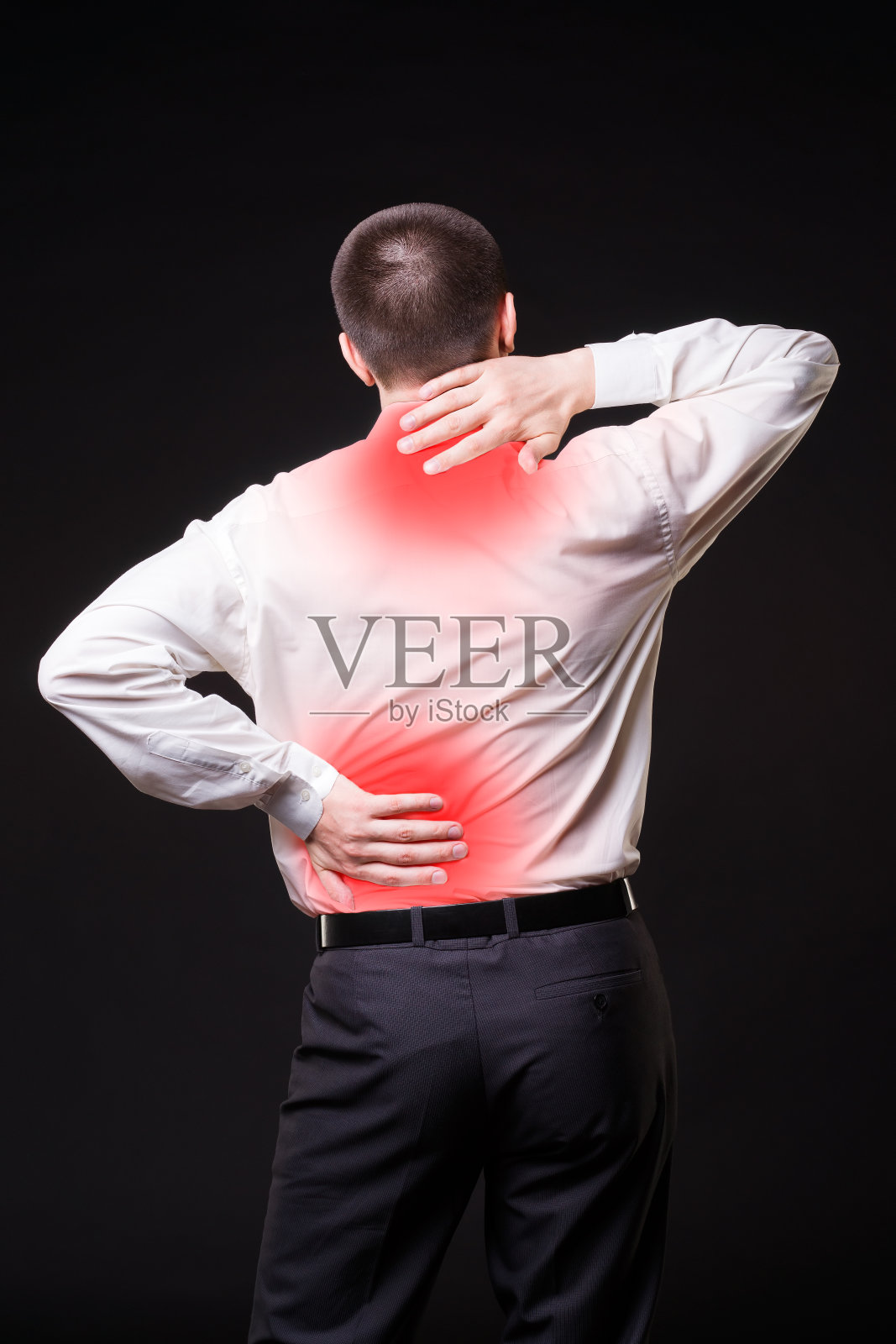 背部疼痛，背部疼痛的男人在黑色背景上照片摄影图片