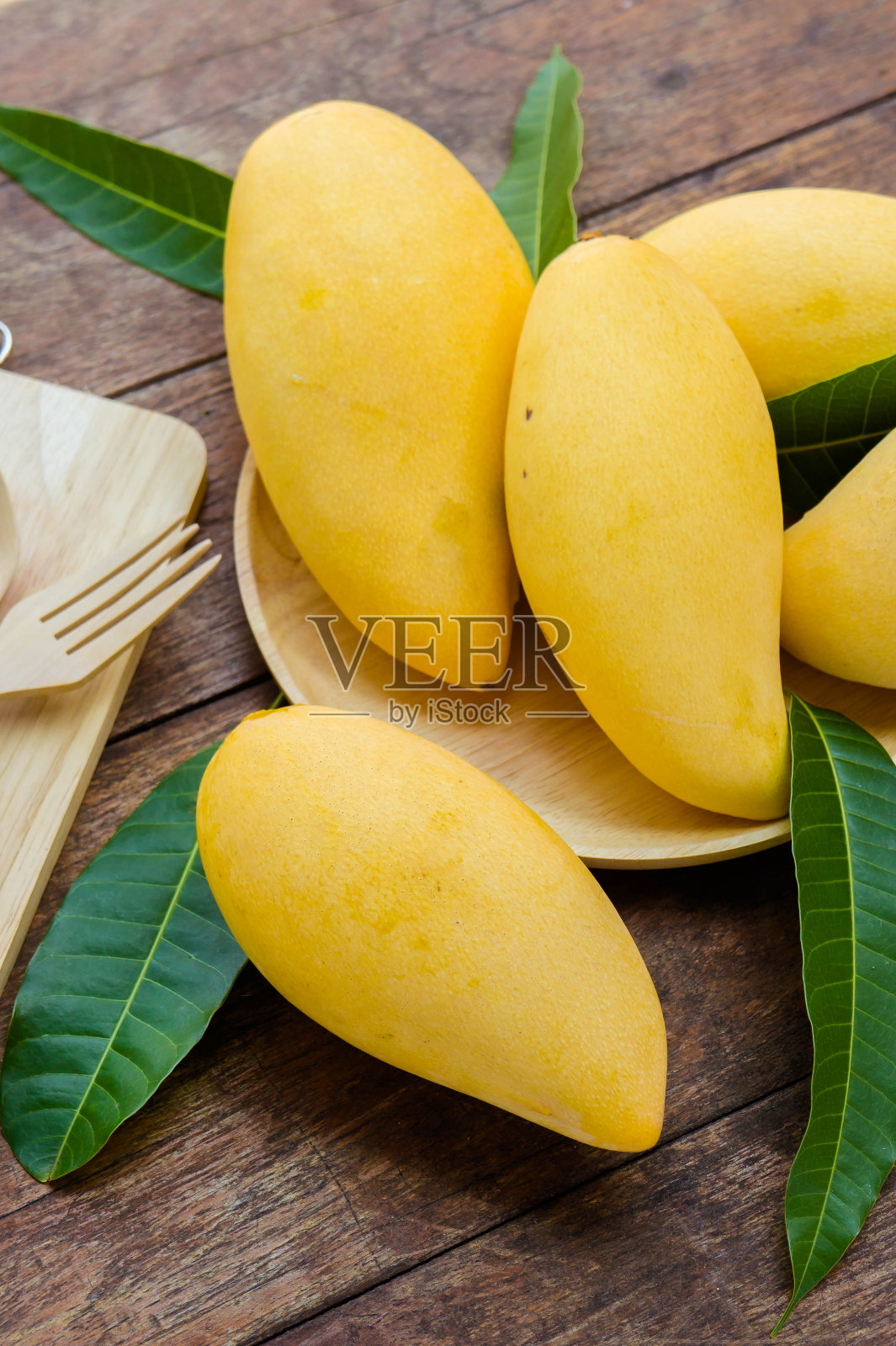 甜美的黄色芒果果实放在夏天的木桌上照片摄影图片