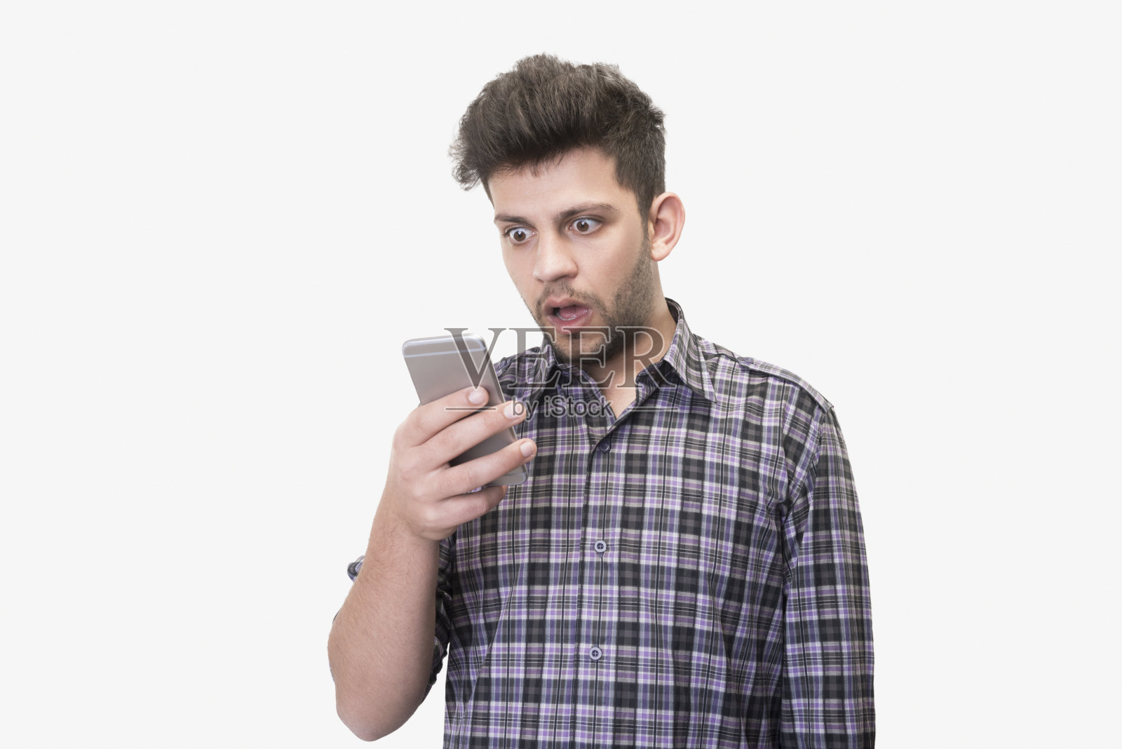 一名震惊的年轻人的特写照片，他看着智能手机的屏幕，在白色背景上接收到坏消息照片摄影图片