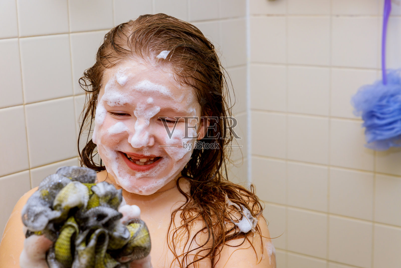 快乐的小女孩正在用泡沫洗澡照片摄影图片
