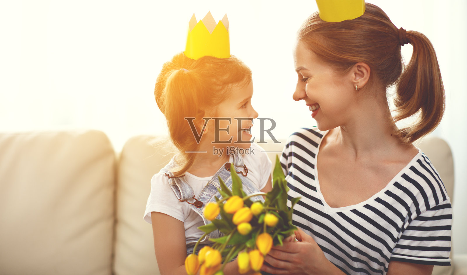 母亲节快乐!母亲和女儿戴着花冠和鲜花照片摄影图片