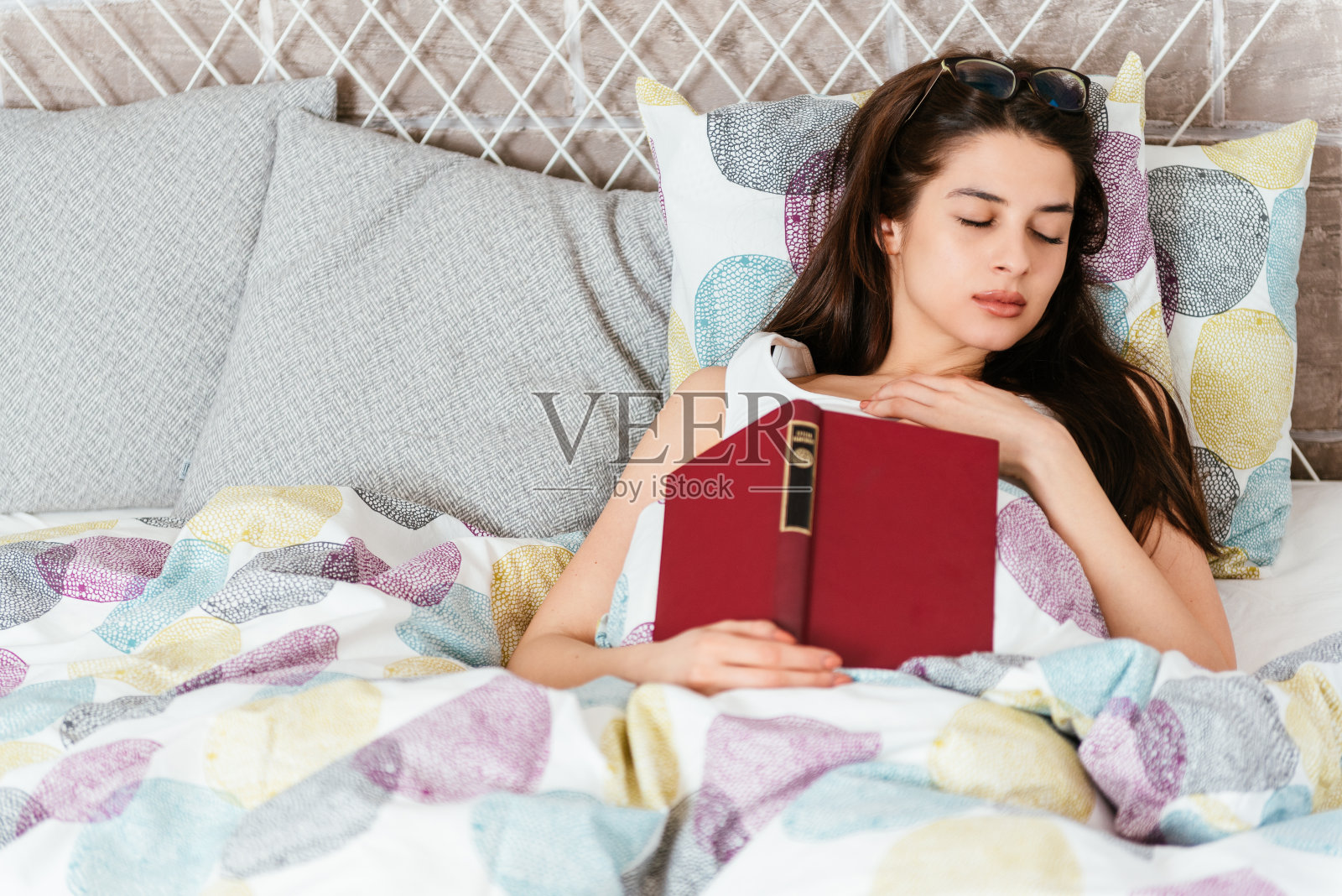 年轻漂亮的女人在看书的时候睡着了照片摄影图片