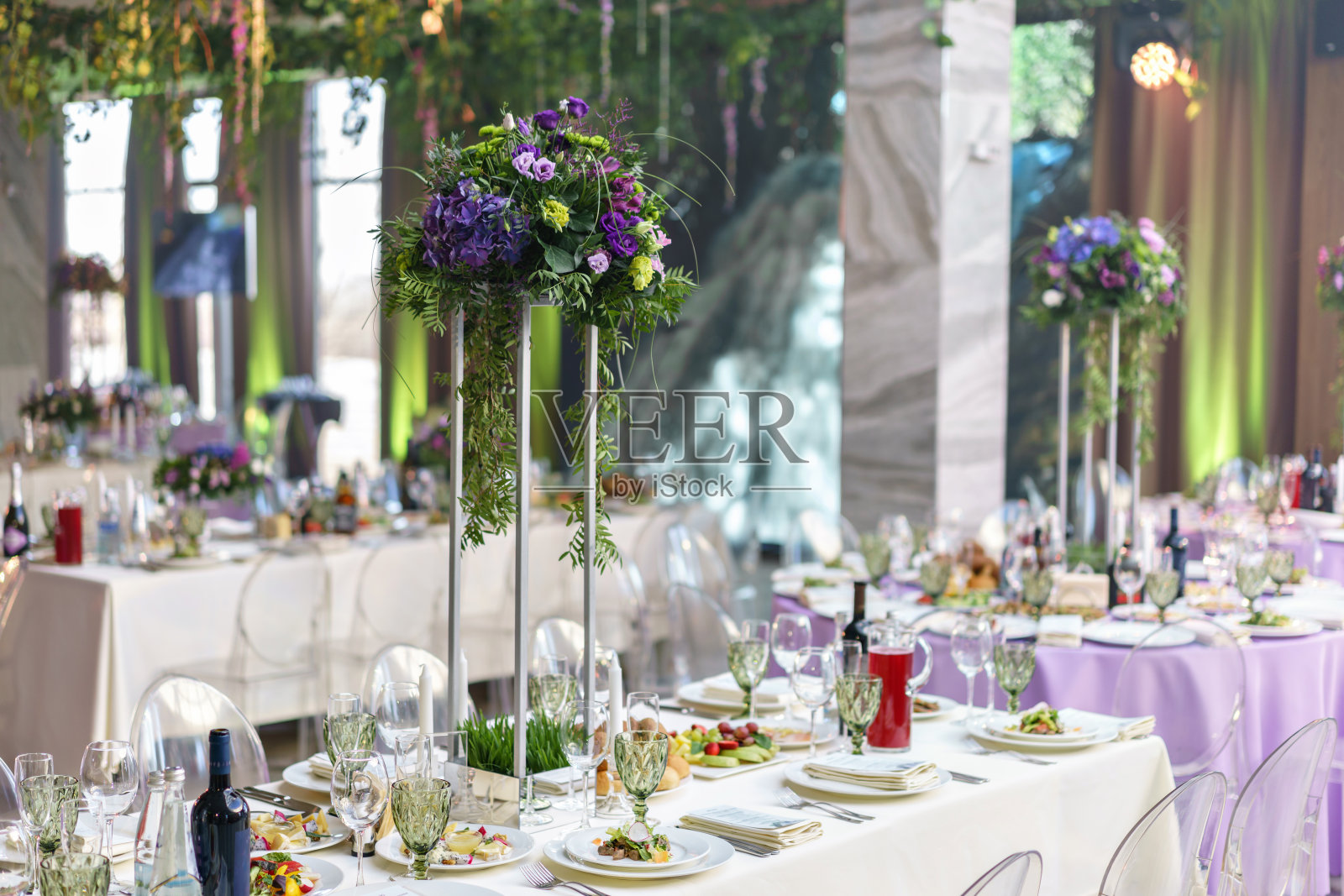 漂亮的绣球花束插在高高的架子上。餐厅豪华婚宴餐桌插花。时尚的装饰和装饰照片摄影图片
