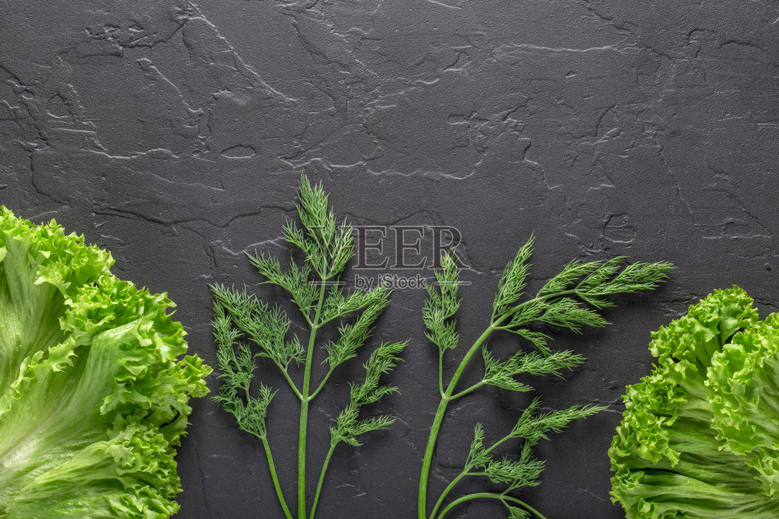 欧芹，莳萝，卷心菜叶，胡椒在黑色混凝土背景。沙拉和素食的新鲜产品。照片摄影图片