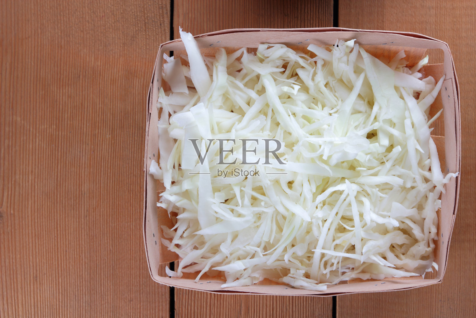 切碎的白色卷心菜在木制的背景下，卷心菜为烹饪在一个木制的盒子，素菜，拷贝空间，新鲜蔬菜在一个家庭厨房，乡村风格照片摄影图片