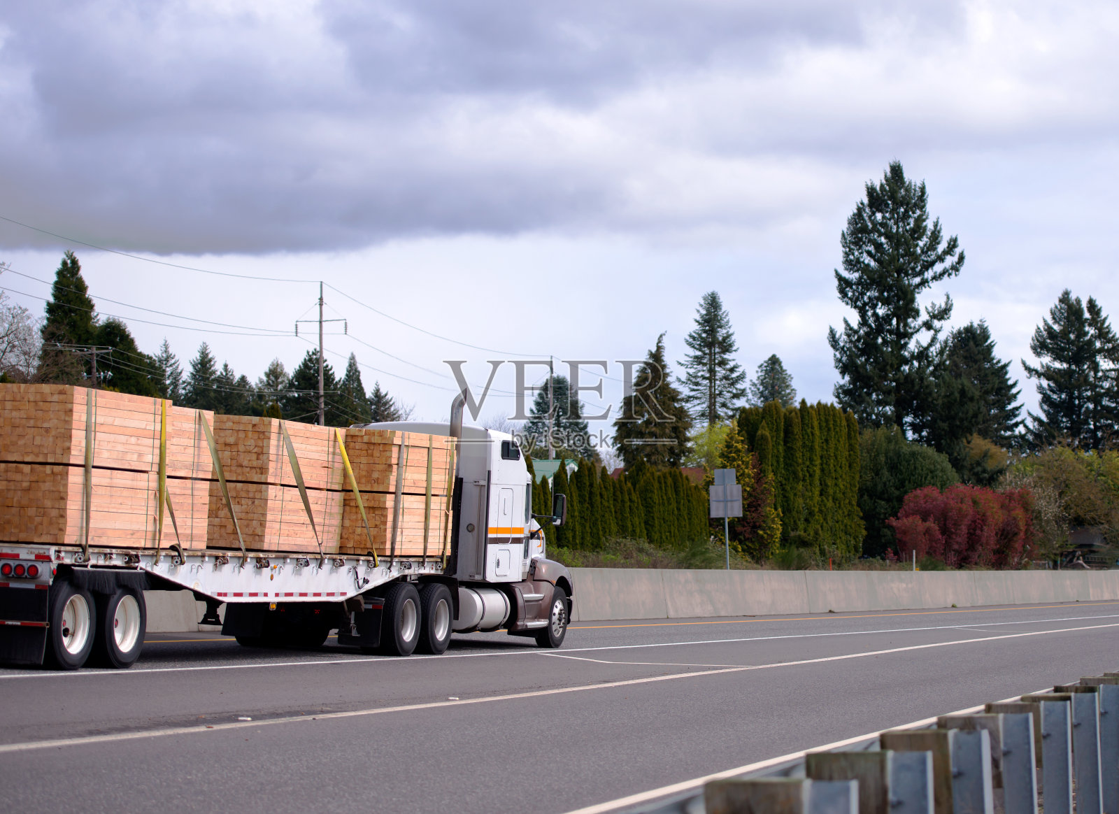 强大的大钻机半挂车与平板半挂车运输木材在笔直的公路上照片摄影图片