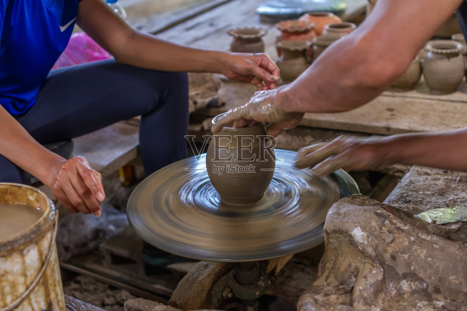 女性的手在陶工车轮上工作的特写照片摄影图片