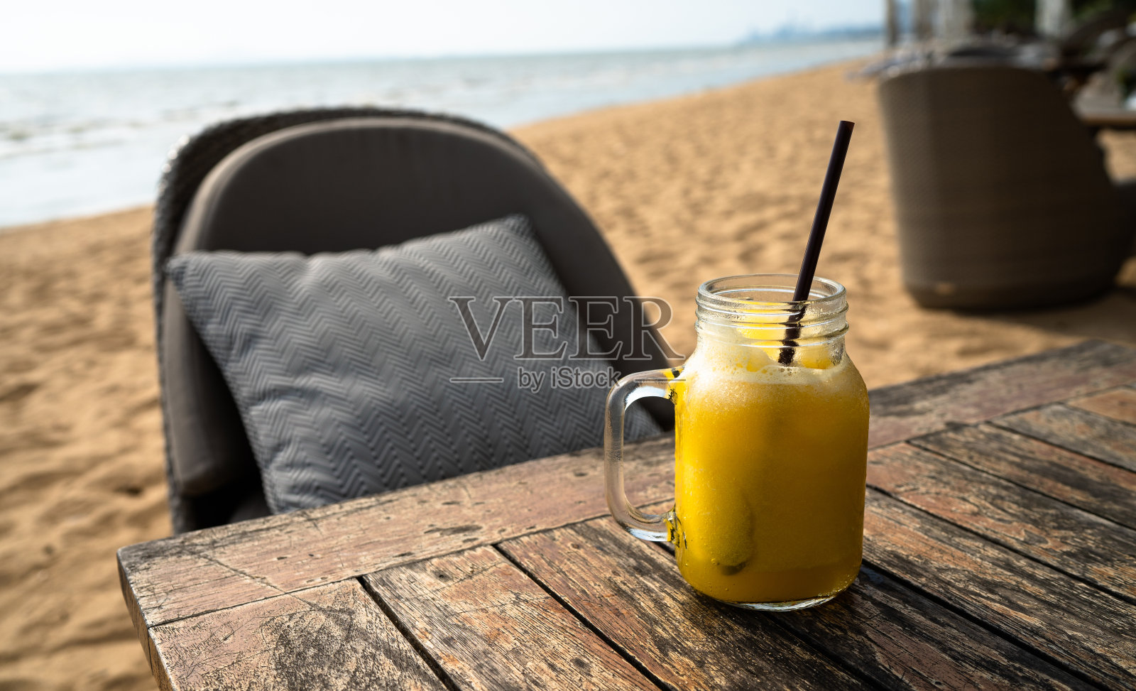 沙滩桌上喝橙汁，夏日清凉清凉的水放松身心，拷贝空间。照片摄影图片