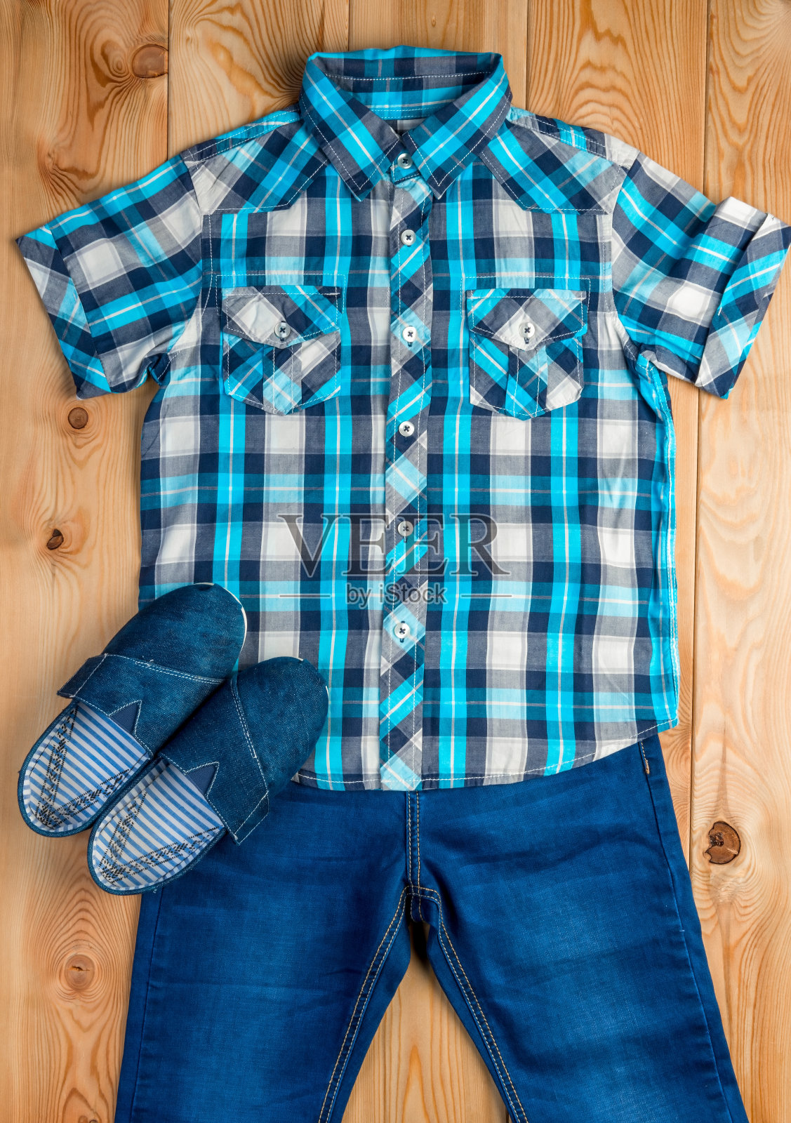 鞋子，蓝色格子衬衫和牛仔裤为一个男孩设置在木地板顶视图照片摄影图片