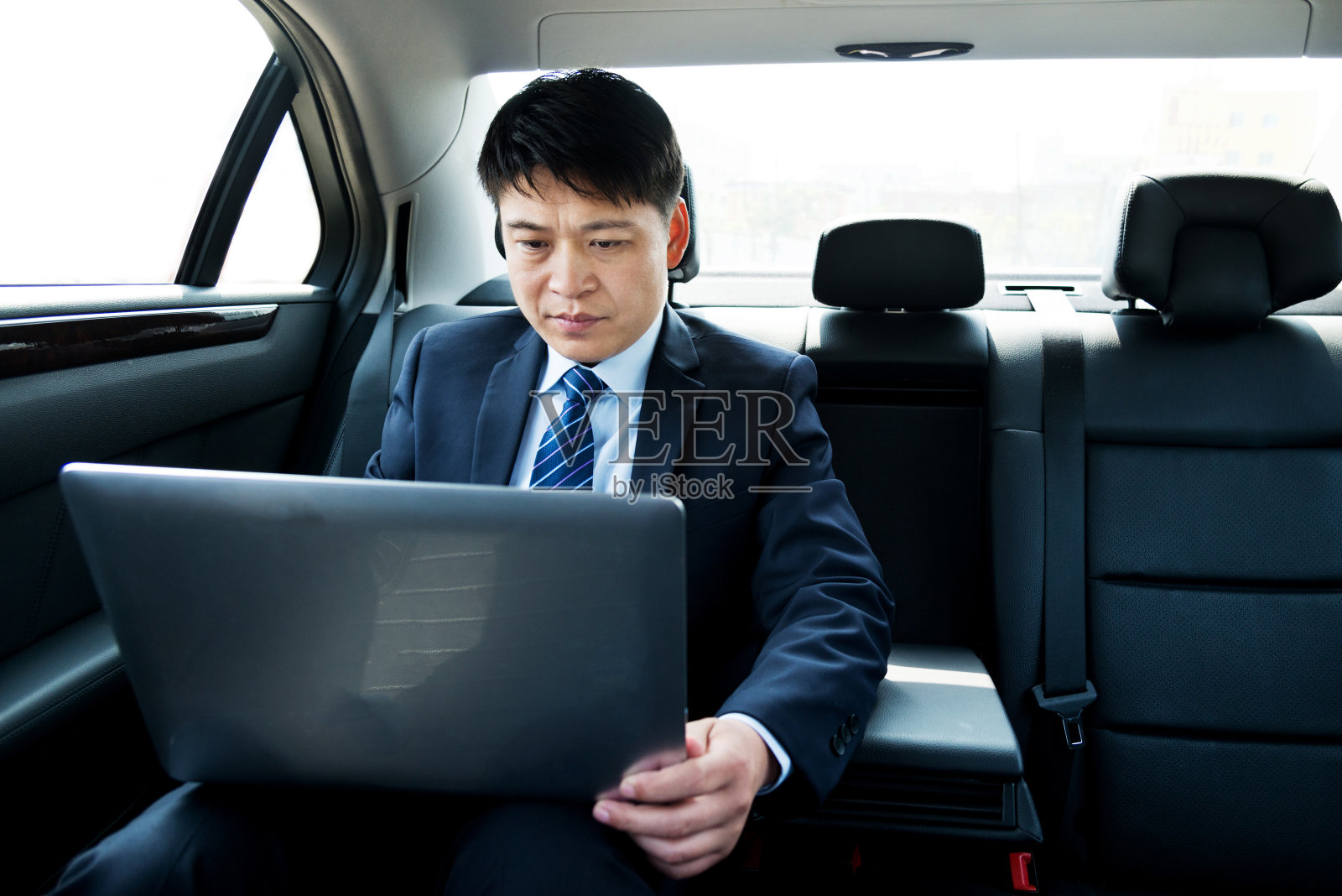 在车里使用笔记本电脑的商人照片摄影图片