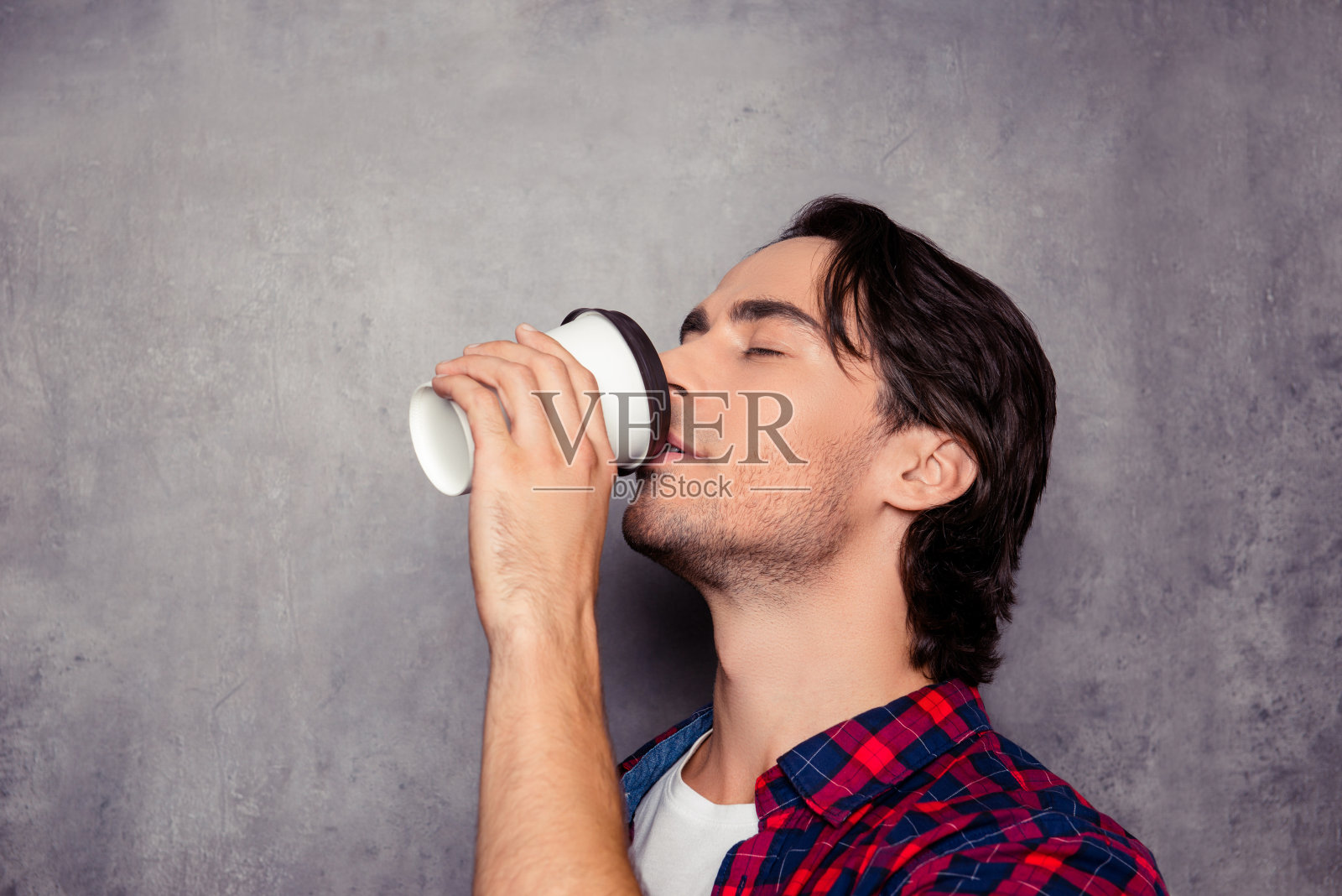 肖像年轻英俊的男子喝咖啡在灰色的背景照片摄影图片
