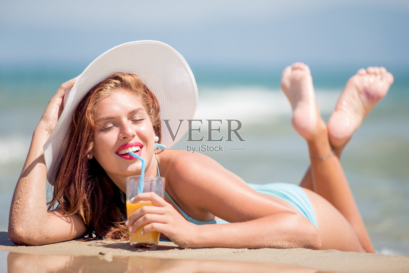 快乐的年轻女子在海滩上休息照片摄影图片