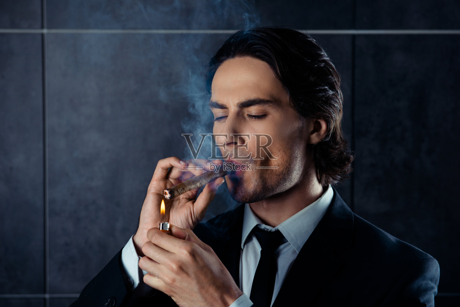 特写肖像的野蛮的年轻人点燃一支雪茄照片摄影图片