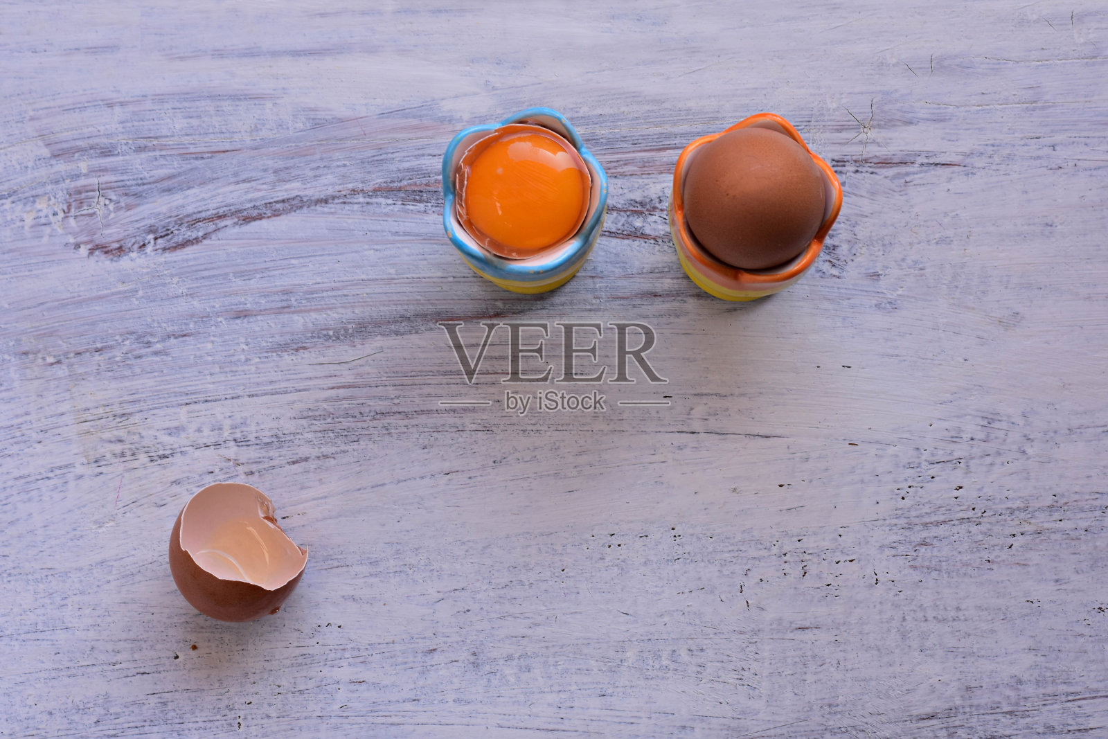 2个煮鸡蛋装在鸡蛋杯里，以浅色的木制背景/健康的早餐/早上好照片摄影图片