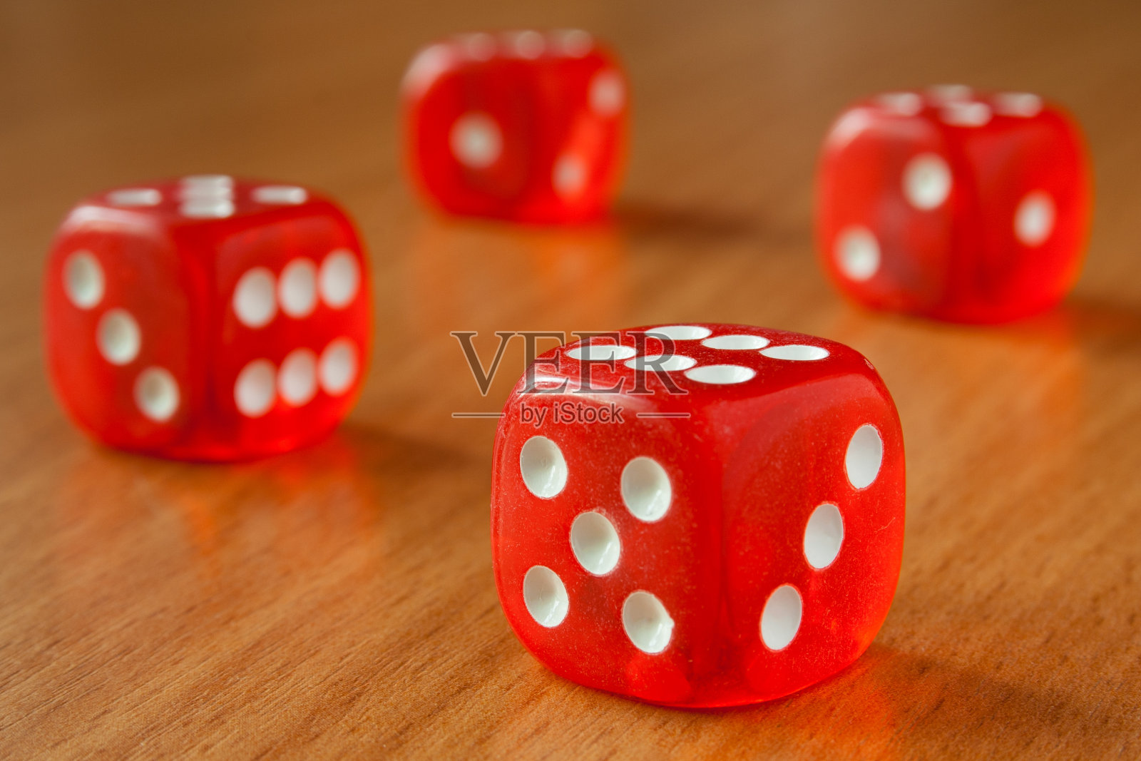 阳光照在木桌上的四个红色骰子照片摄影图片