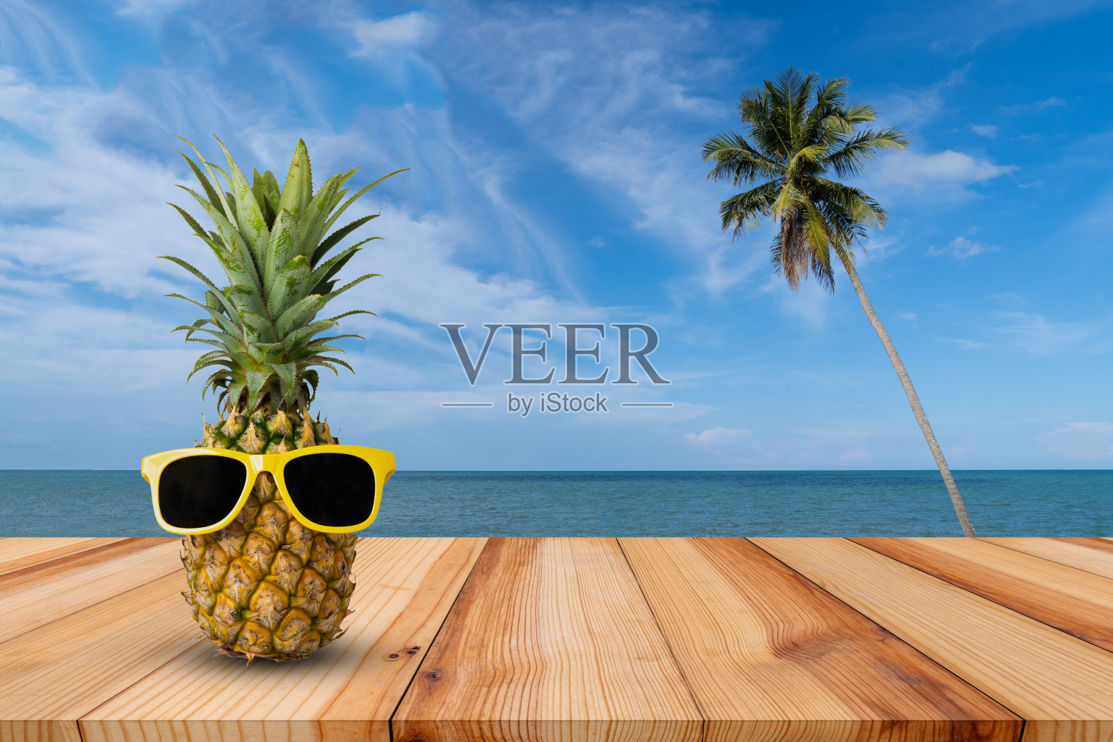 热带景观木桌上的菠萝，时尚潮人的菠萝，明亮的夏日色彩，热带水果配墨镜，创意的艺术概念，极简风格照片摄影图片