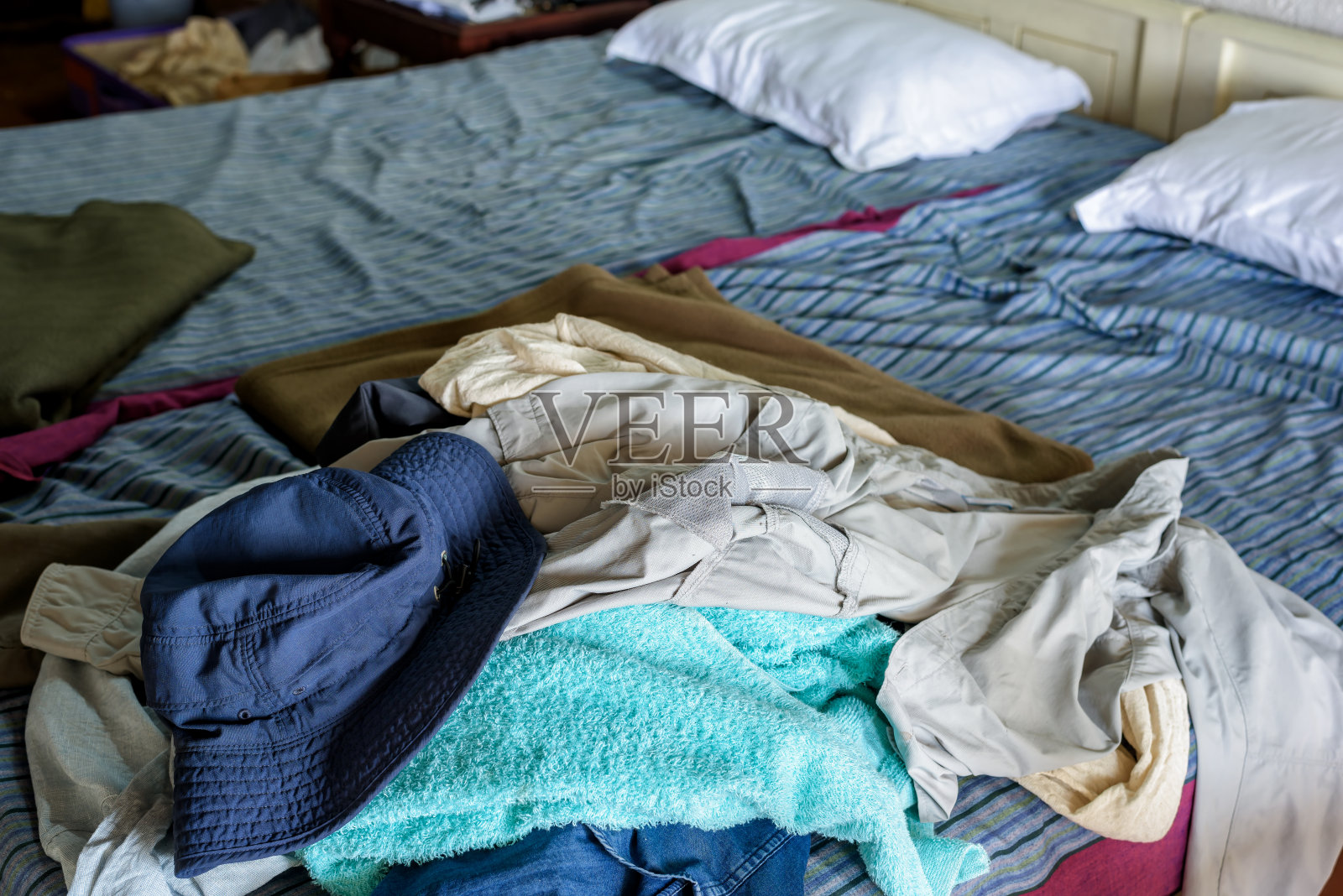 床上一堆没洗过的脏衣服。照片摄影图片