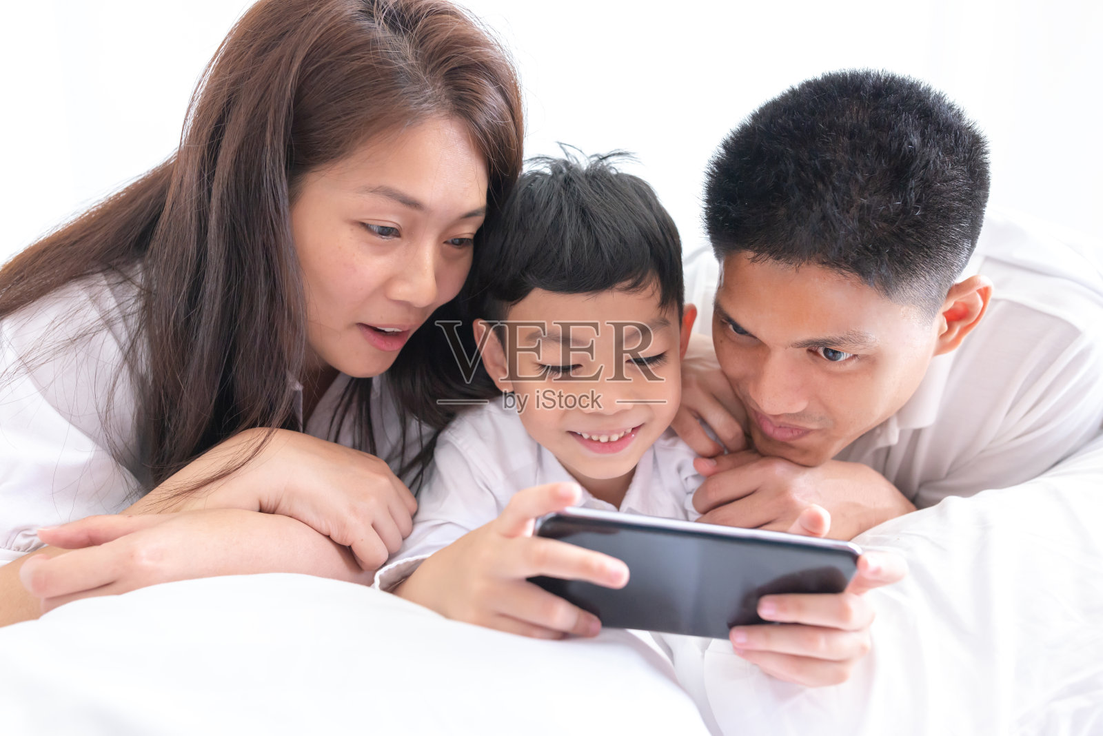 幸福家庭使用智能手机。照片摄影图片