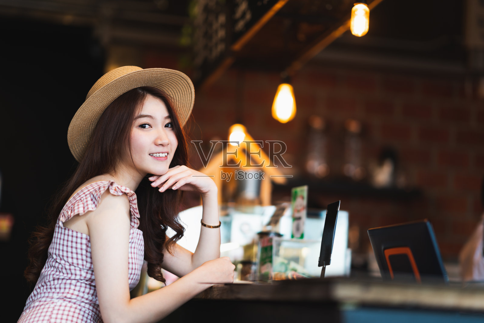 肖像可爱和美丽的亚洲少女微笑在咖啡店与复制空间。咖啡文化休闲的生活方式，快乐的旅行者女人，或休闲放松的假日概念照片摄影图片