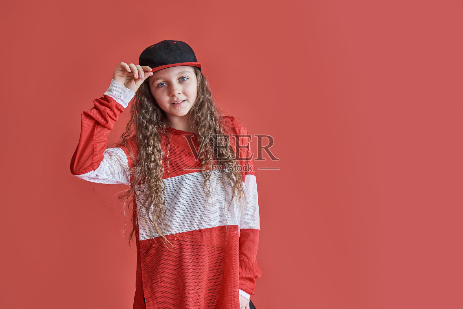 年轻的城市女人在红色的背景下跳舞，现代苗条的嘻哈风格的少女照片摄影图片