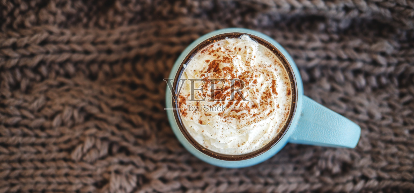 一杯咖啡，可可或热巧克力，奶油和肉桂编织围巾。南瓜拿铁秋季舒适饮料寒冷的夜晚。秋冬温馨家的概念。照片摄影图片