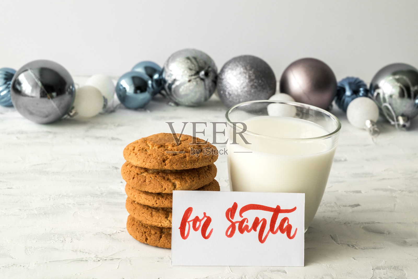 饼干，圣诞玩具，牛奶杯和刻有圣诞老人字样的盘子。圣诞假期概念及对圣诞老人的期望。有选择性的重点。照片摄影图片