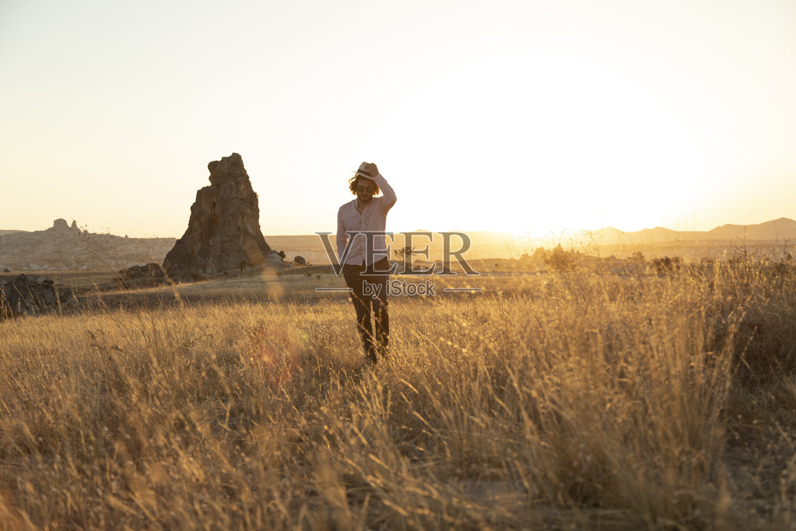 日落时分，一个年轻人在乡间散步照片摄影图片