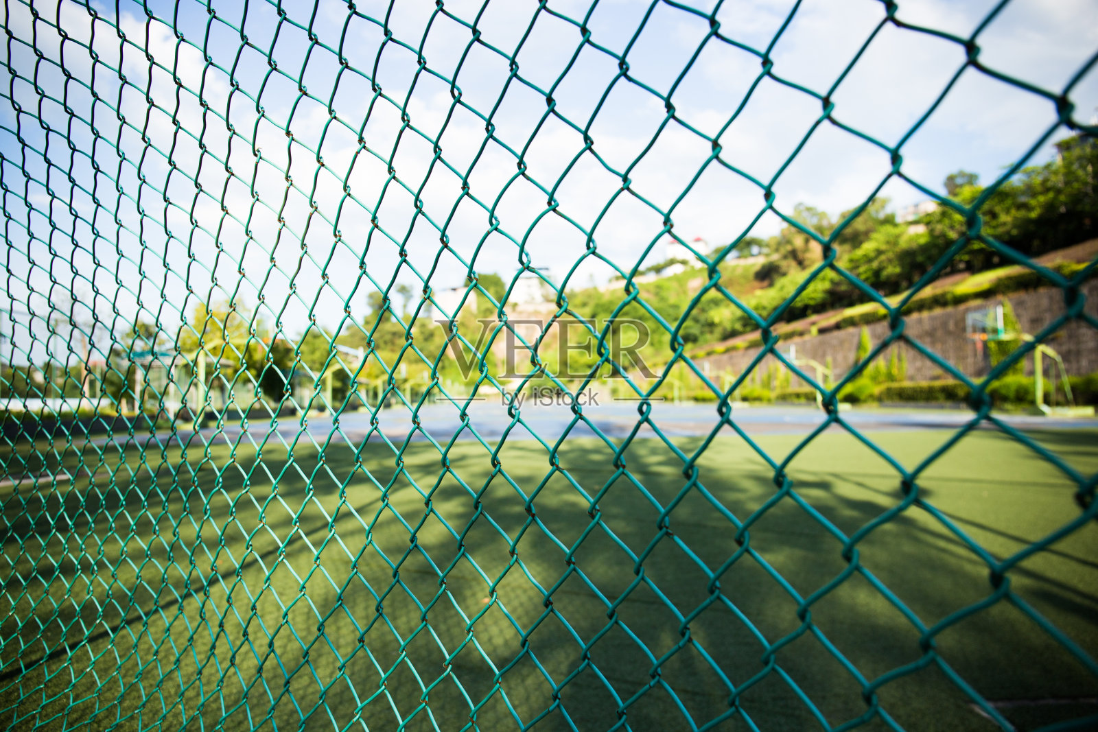 学校足球场边上的绿色带刺铁丝网照片摄影图片