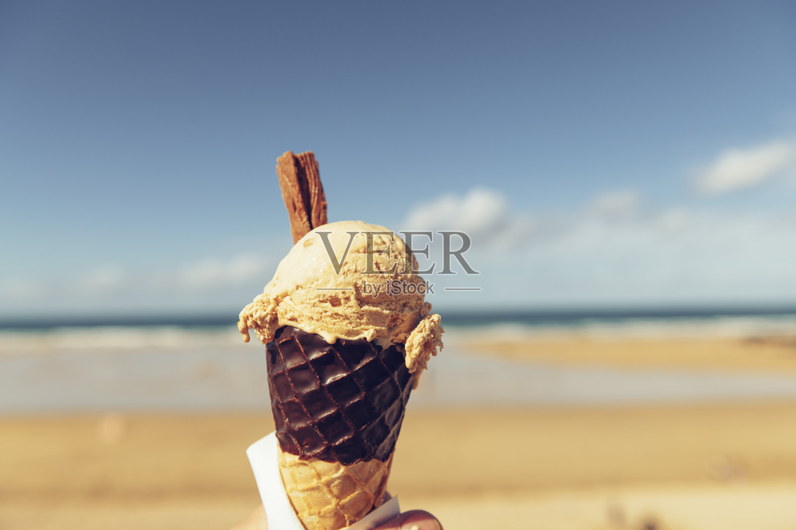 在一个阳光明媚的九月，康沃尔纽基菲斯特拉海滩的腌制焦糖冰淇淋蛋筒。照片摄影图片