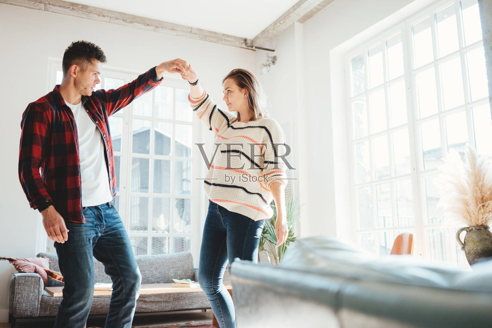 家庭生活。快乐的年轻夫妇在家里跳舞照片摄影图片