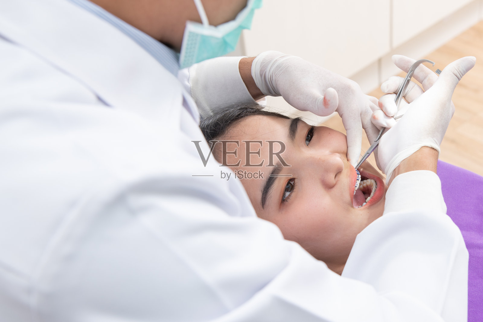 牙医正在检查女病人的牙齿照片摄影图片