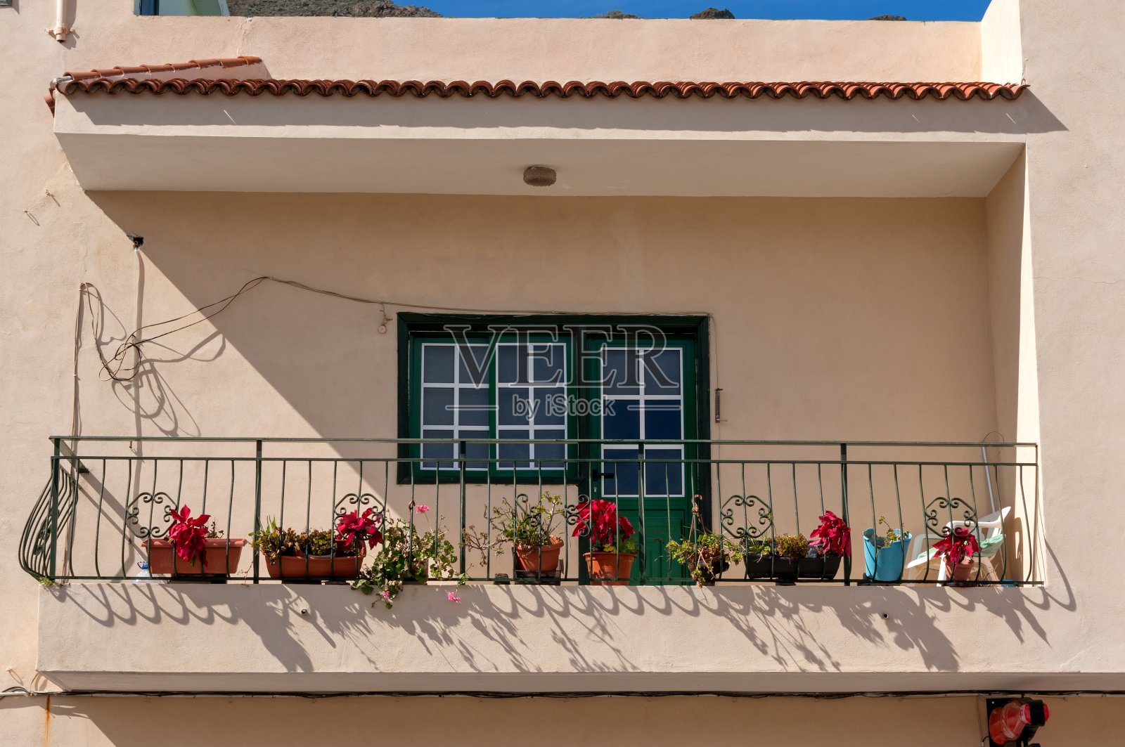 在一个古老的白色建筑上的阳台，装饰着盆花在西班牙城市照片摄影图片