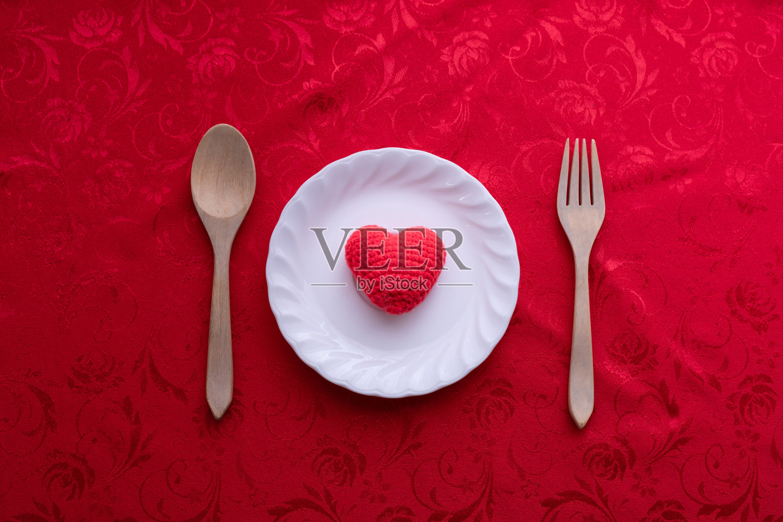 红色桌布与心形标志的盘子，情人节的背景。照片摄影图片