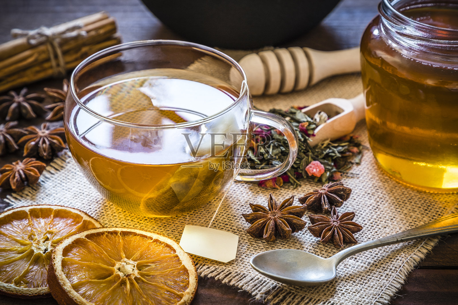 喝茶时间:一杯茶，肉桂棒，八角，橘子干放在木桌上照片摄影图片