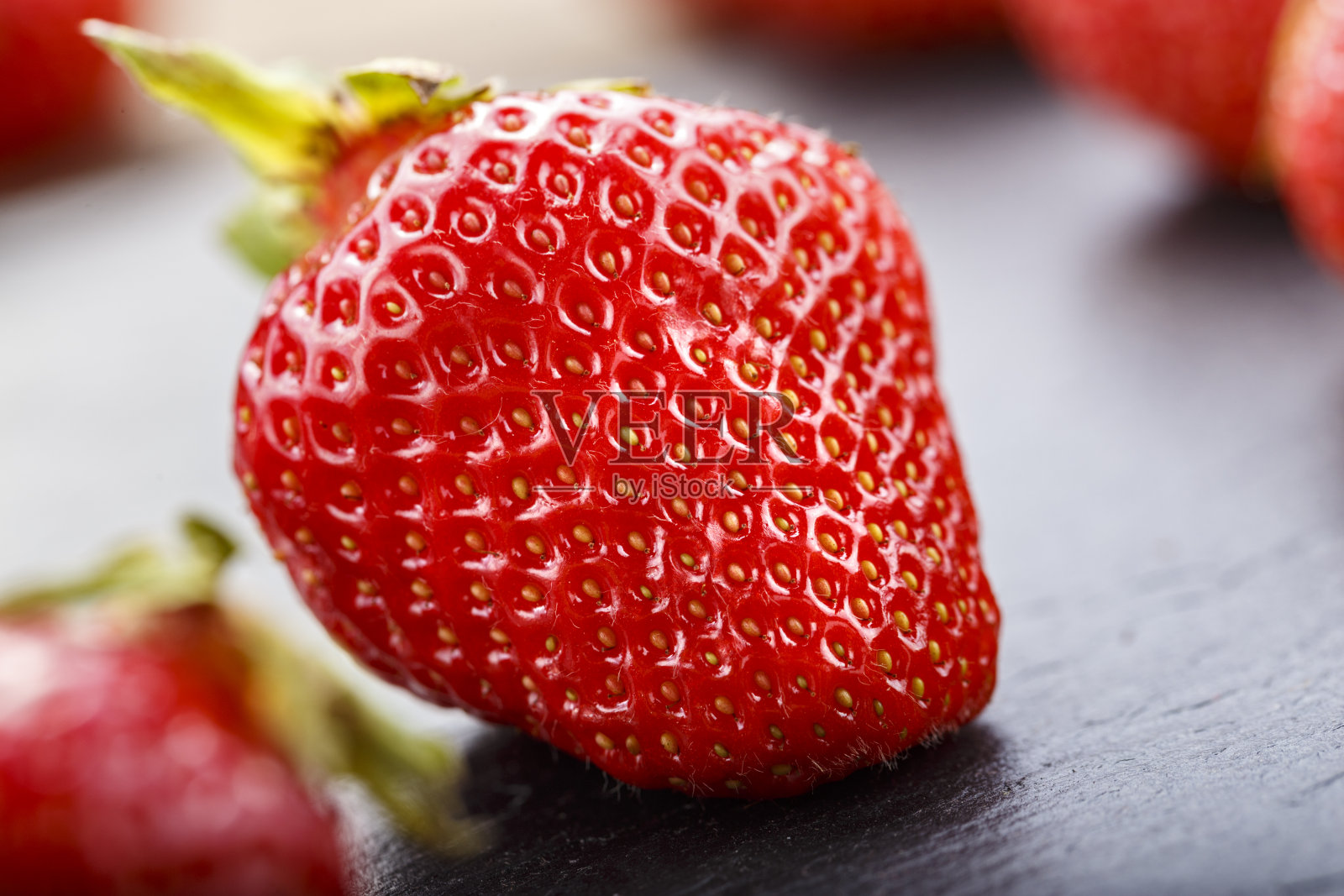 成熟的草莓上的黑色背景特写。照片摄影图片
