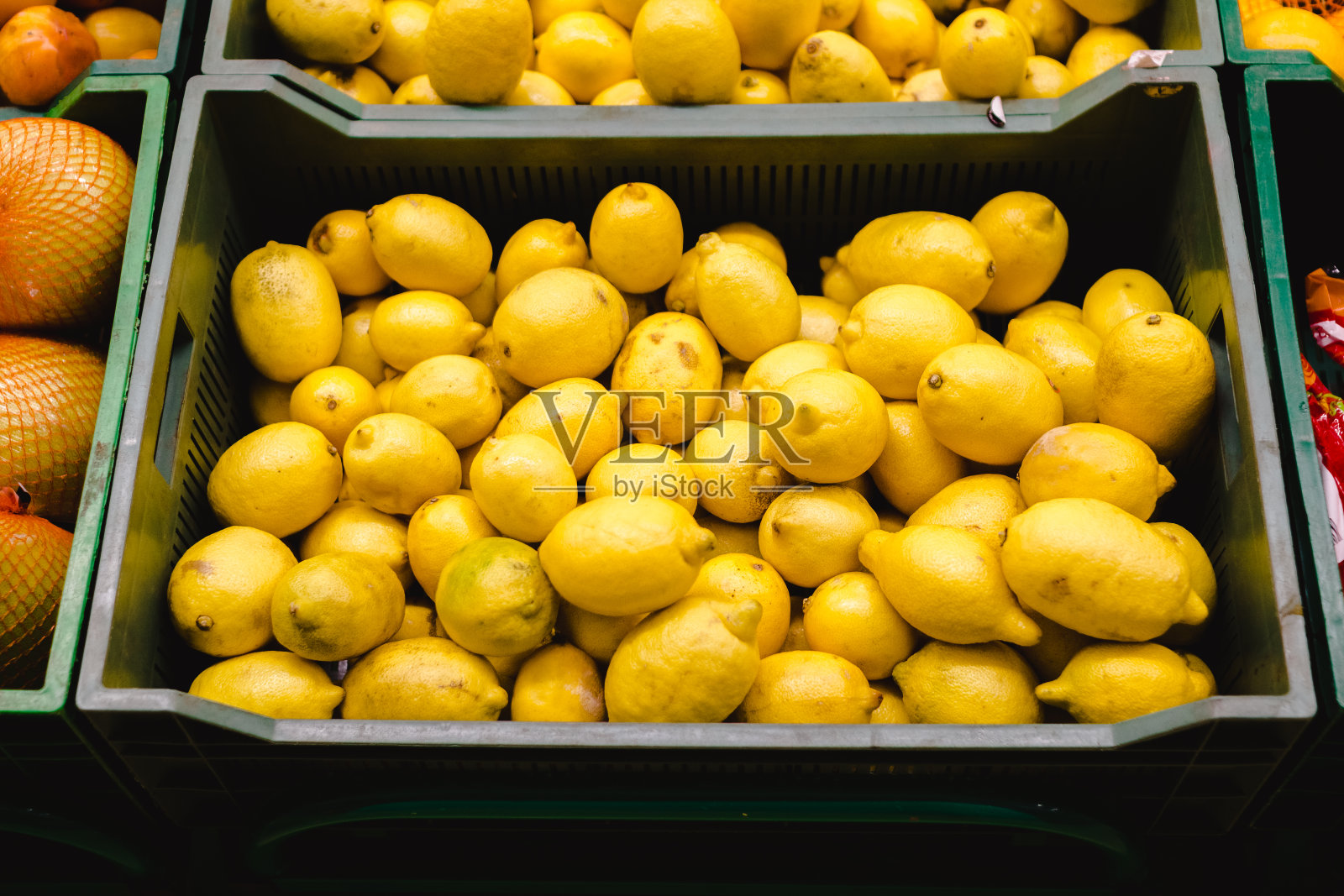 超市里一堆盒子上的柠檬和橙子照片摄影图片