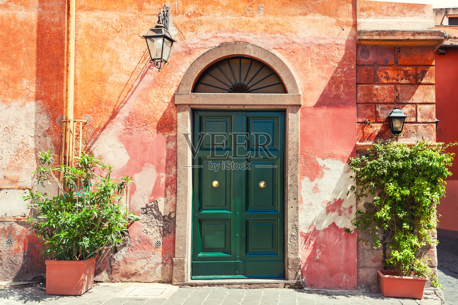 房子的旧红墙上的绿门。罗马,意大利。照片摄影图片