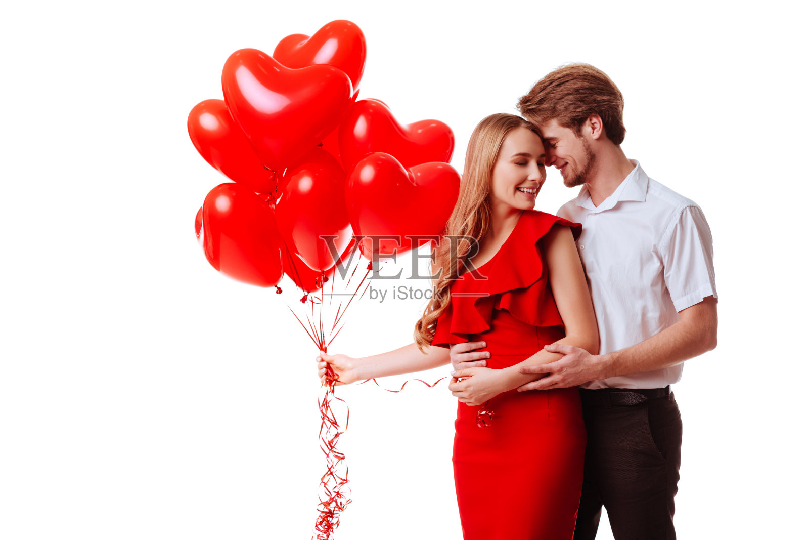 一对情侣在白色背景下摆出心形气球的姿势。照片摄影图片