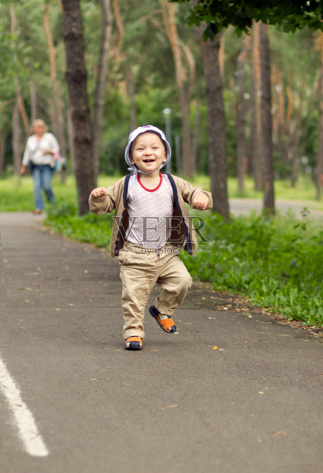 宝宝在公园里学走路。可爱的小男孩在学走路照片摄影图片