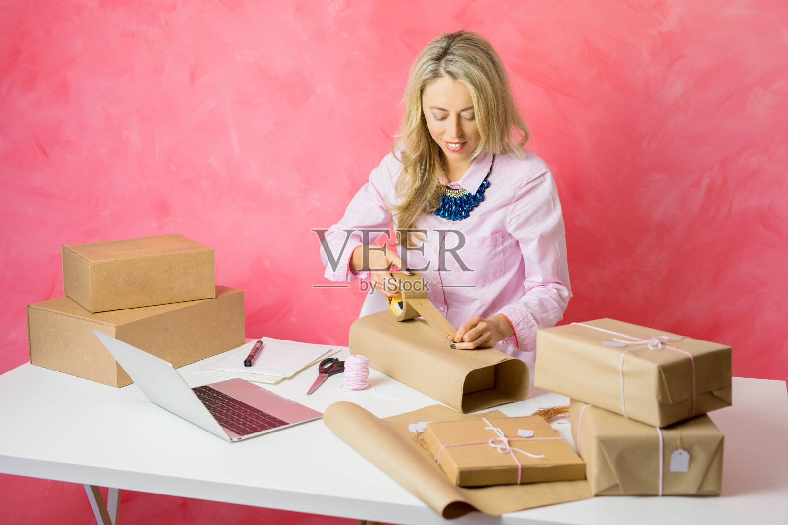 女人在网上销售商品和包装物品的邮件。照片摄影图片