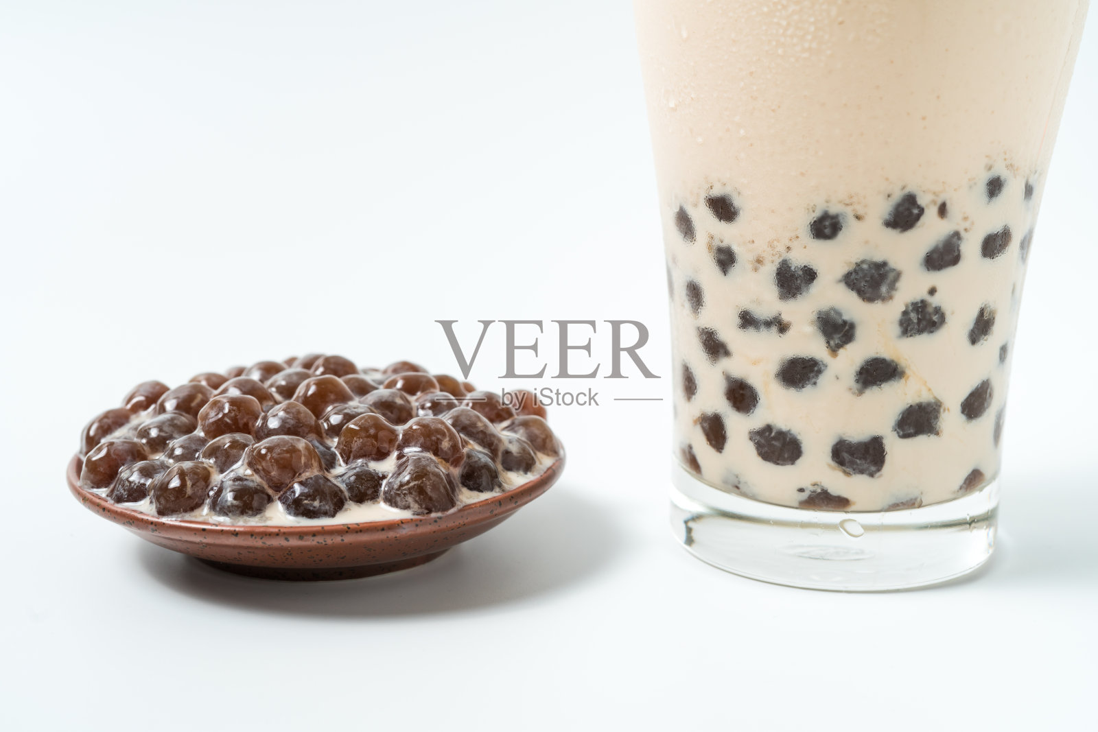 一杯珍珠奶茶(也叫珍珠奶茶)和一盘在白色背景上的木薯球。珍珠奶茶是台湾最具代表性的饮品。台湾的食物。与复制空间。照片摄影图片